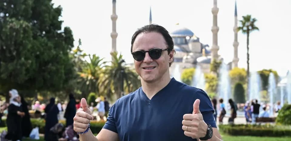 Man giving thumbs up in front of mosque