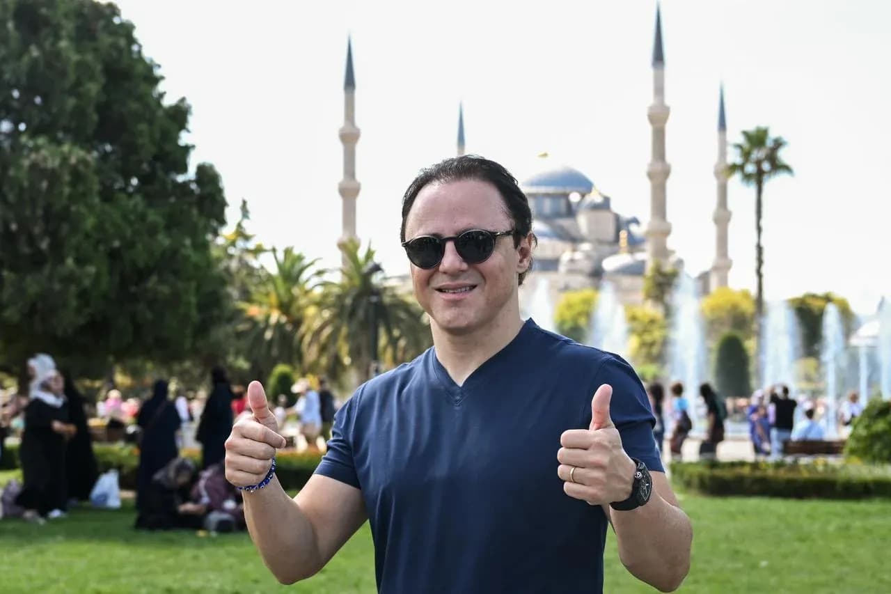 Man giving thumbs up in front of mosque