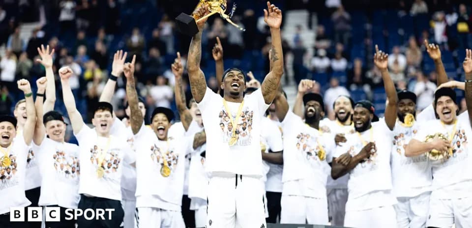 Player holding trophy with teammates celebrating victory