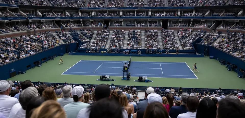 Tennis match in progress at a packed stadium