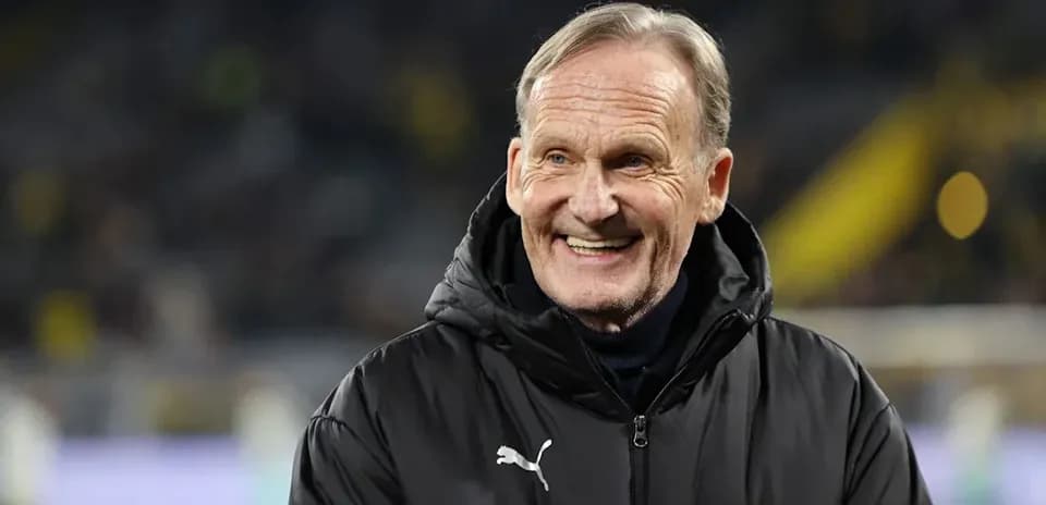 Smiling man in black jacket at football match