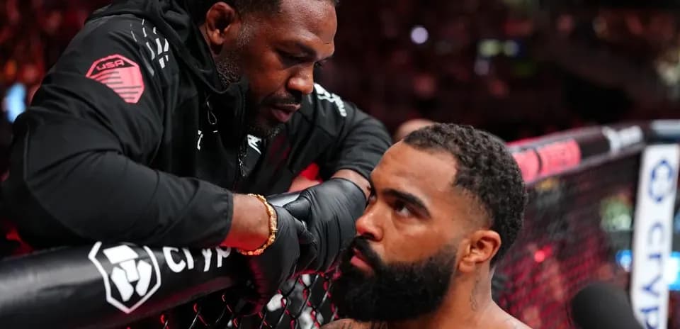 Coach giving instructions to fighter in octagon