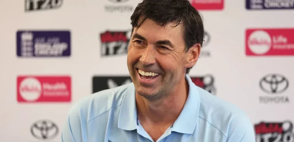 Coach smiling during press conference at venue