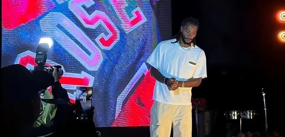 Performer on stage with large screen backdrop