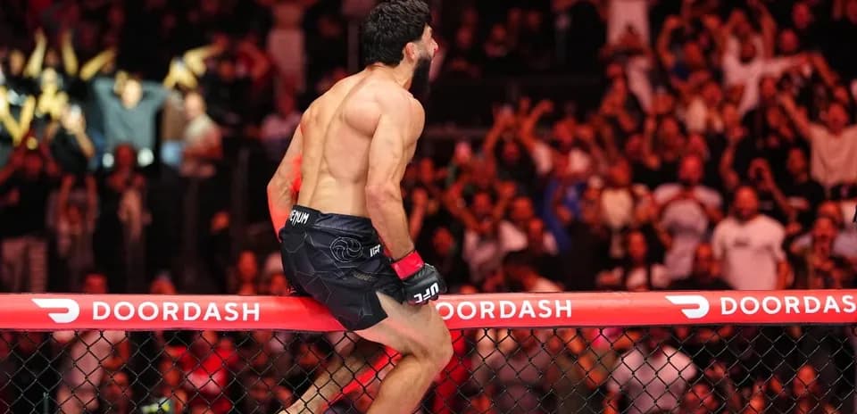 Fighter celebrating victory on the octagon fence