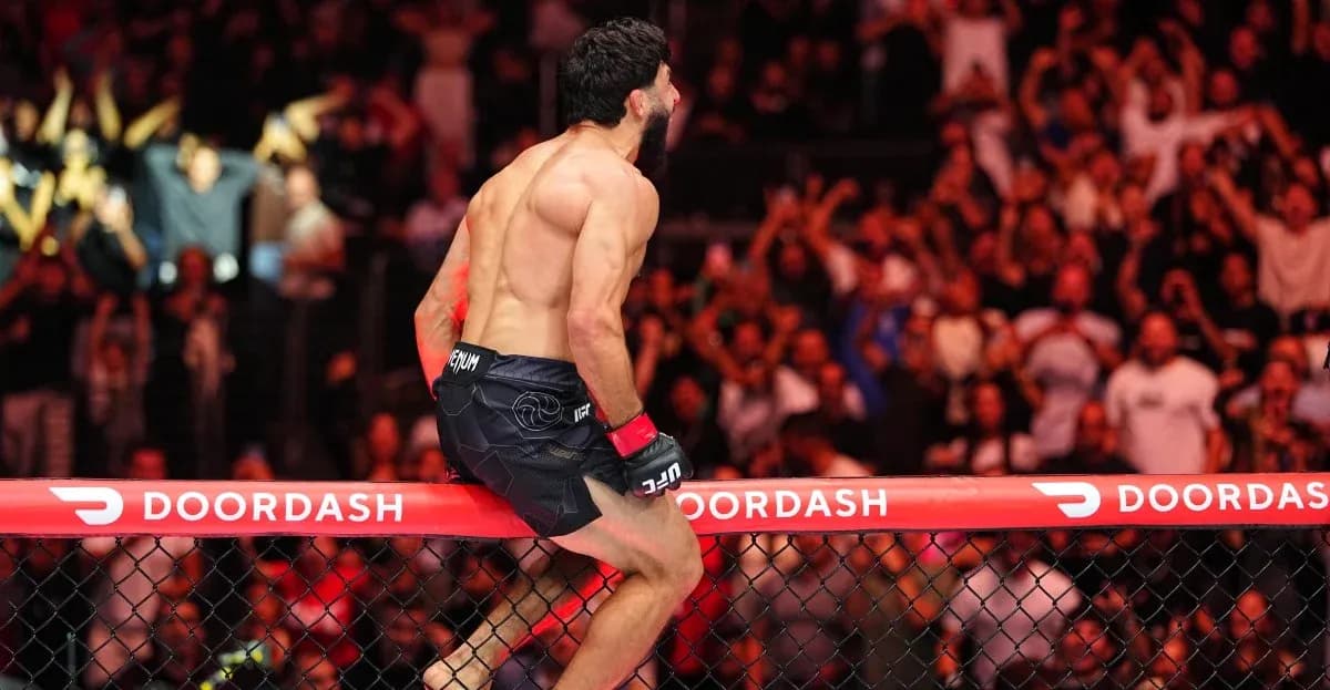 Fighter celebrating victory on the octagon fence