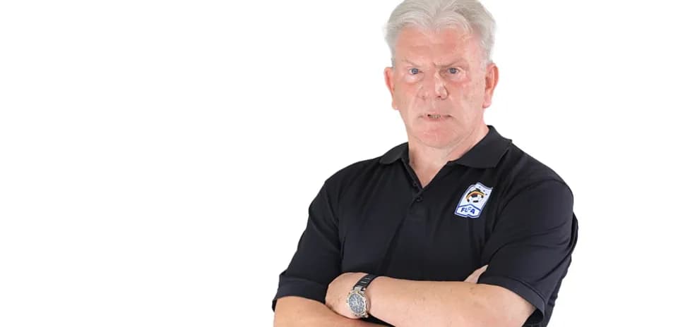 Man with crossed arms wearing a black polo shirt