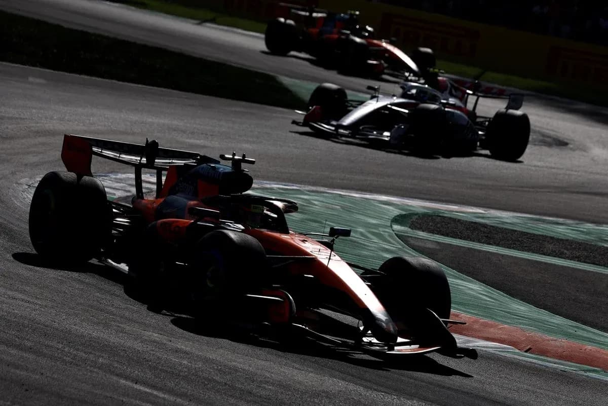 Formula 1 cars racing through a curve on track