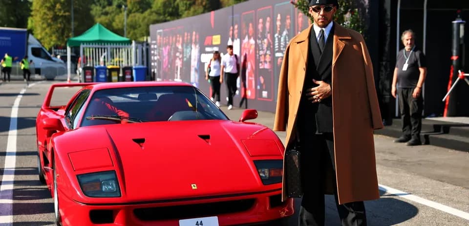 Person in stylish attire beside a red Ferrari