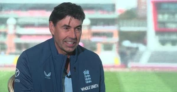 Man speaking during interview at cricket venue