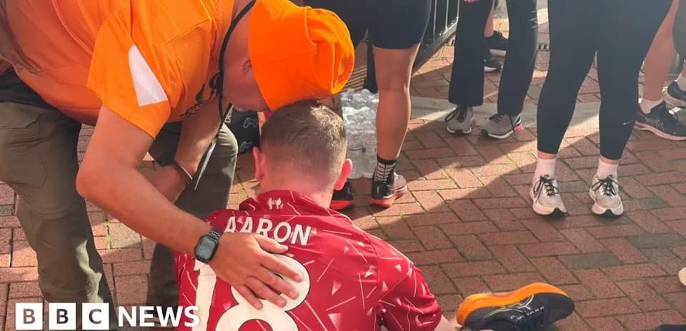 Supporter comforting runner sitting on the ground