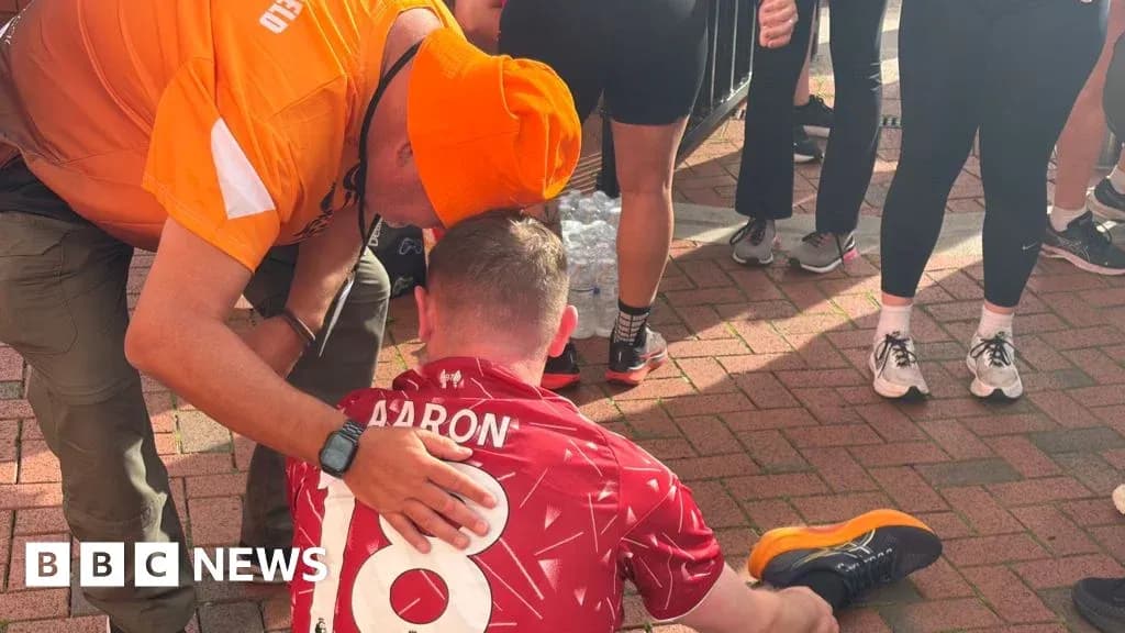 Supporter comforting runner sitting on the ground
