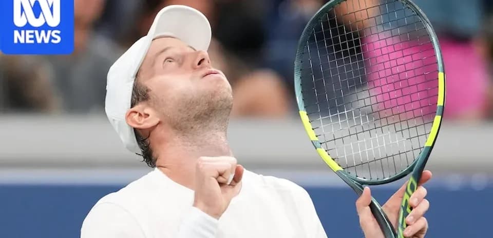Tennis player celebrating with racket raised in victory
