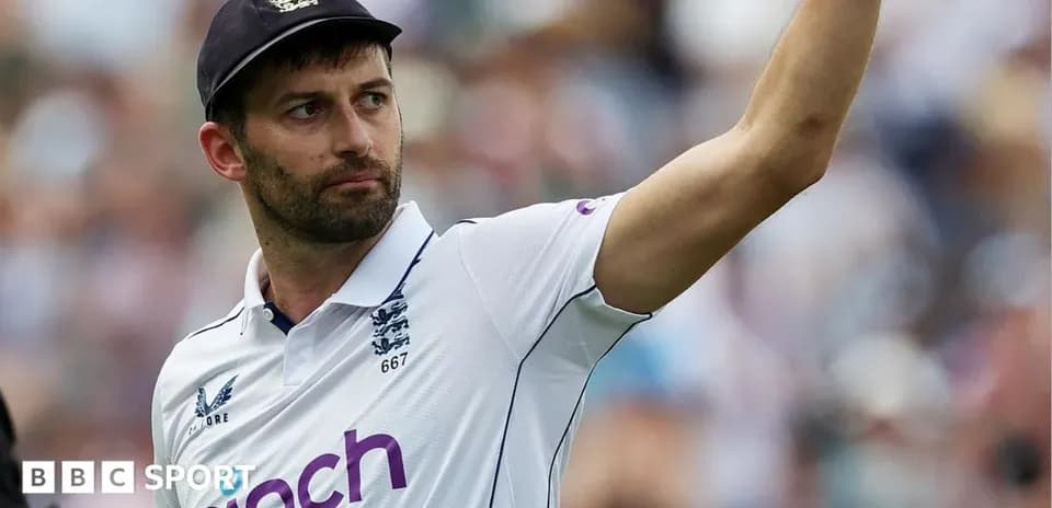 Cricketer in England kit raising hand during match