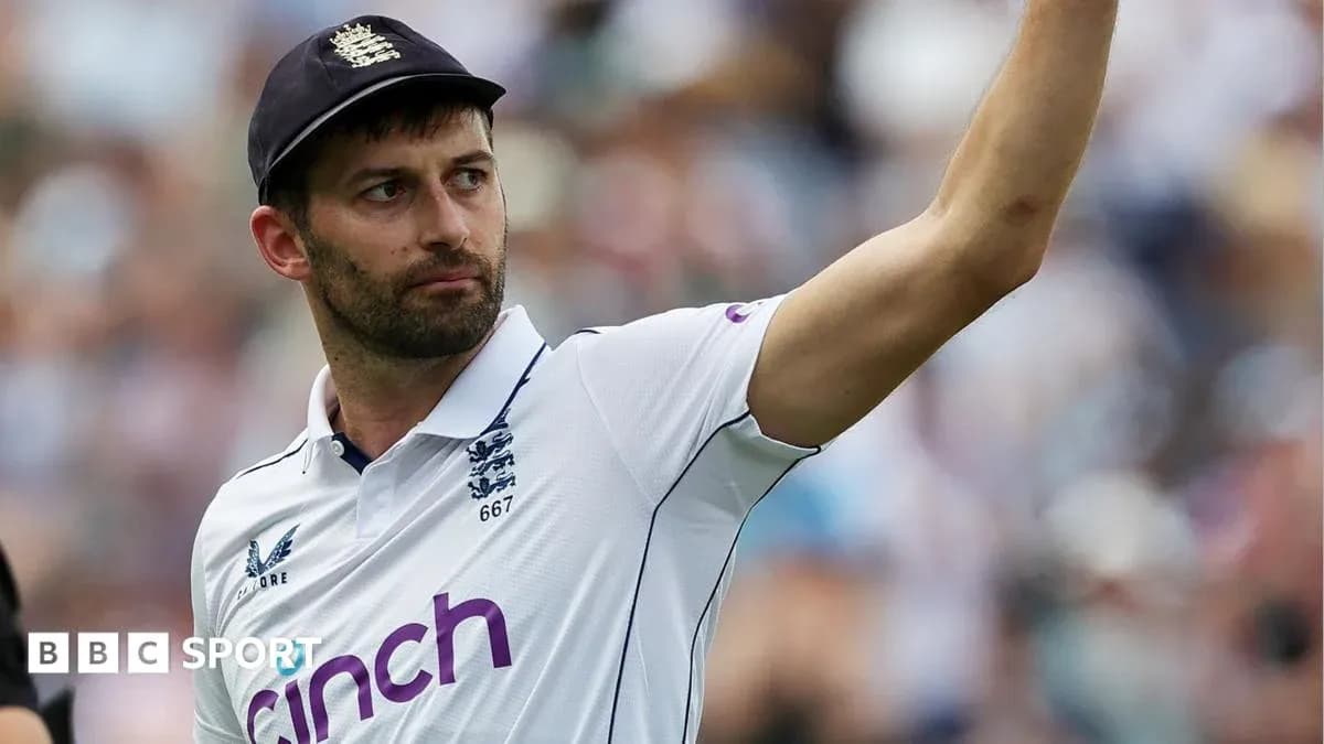 Cricketer in England kit raising hand during match