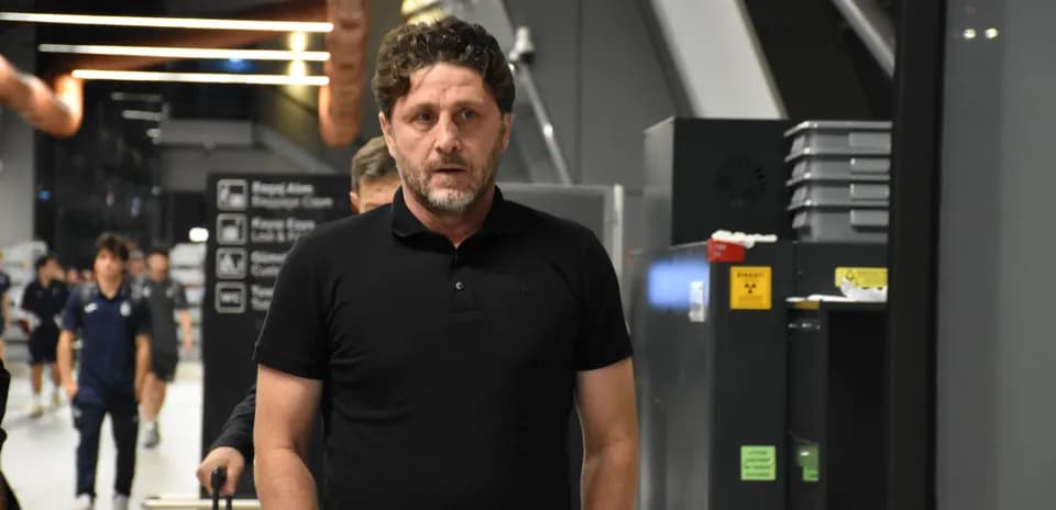 Man walking through airport with team in background