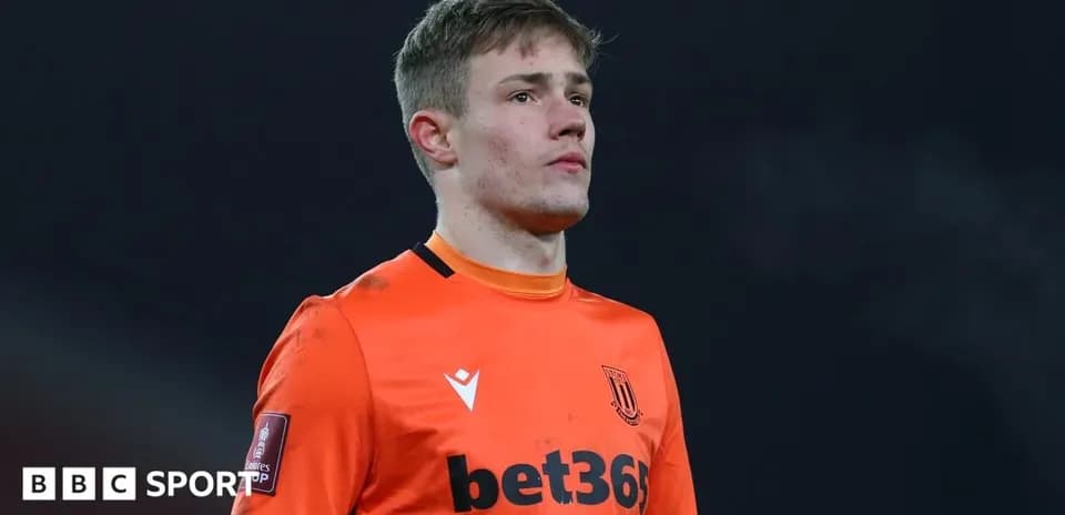 Goalkeeper in orange kit during match action