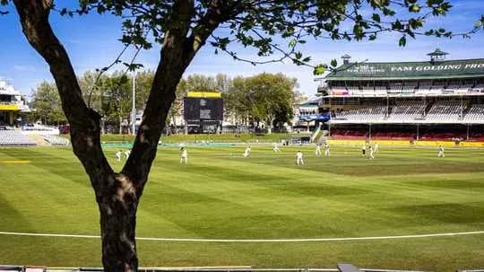 Cricket match in progress at stadium with players