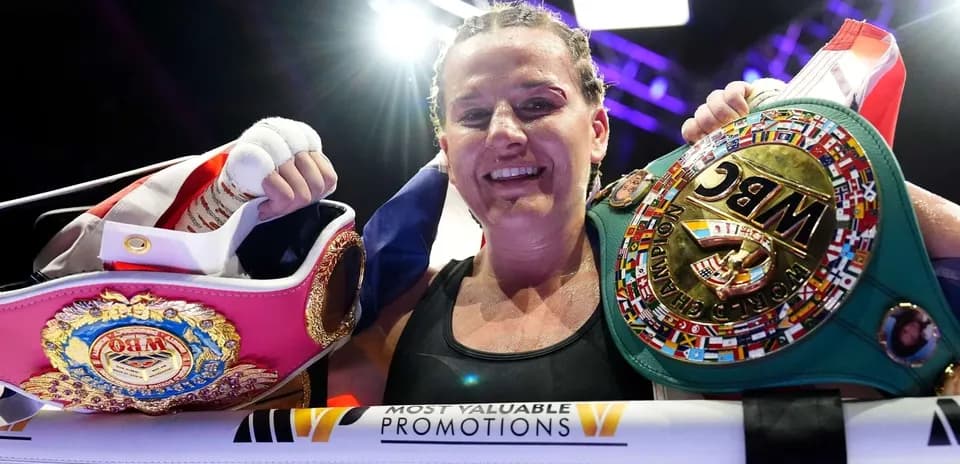 Boxer celebrating with championship belts after match