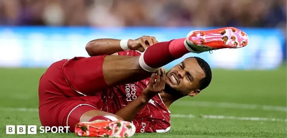 Player in red jersey lying on the field in pain