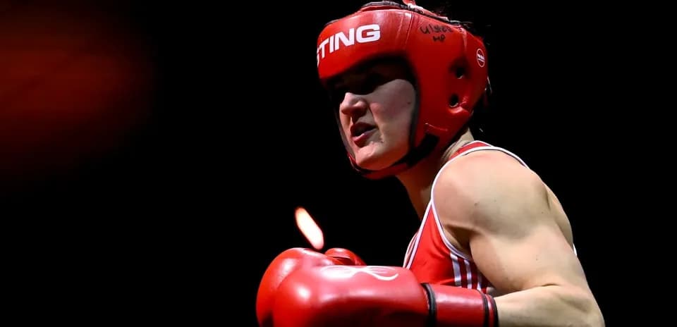 Boxer wearing red gloves and headgear in action