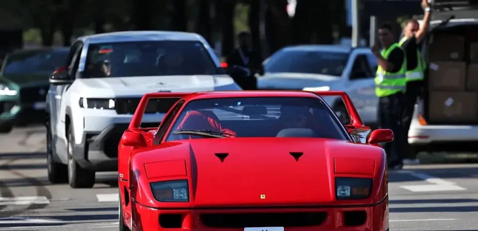Red Ferrari F40 driving through a busy street