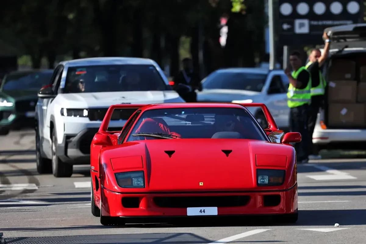 Red Ferrari F40 driving through a busy street