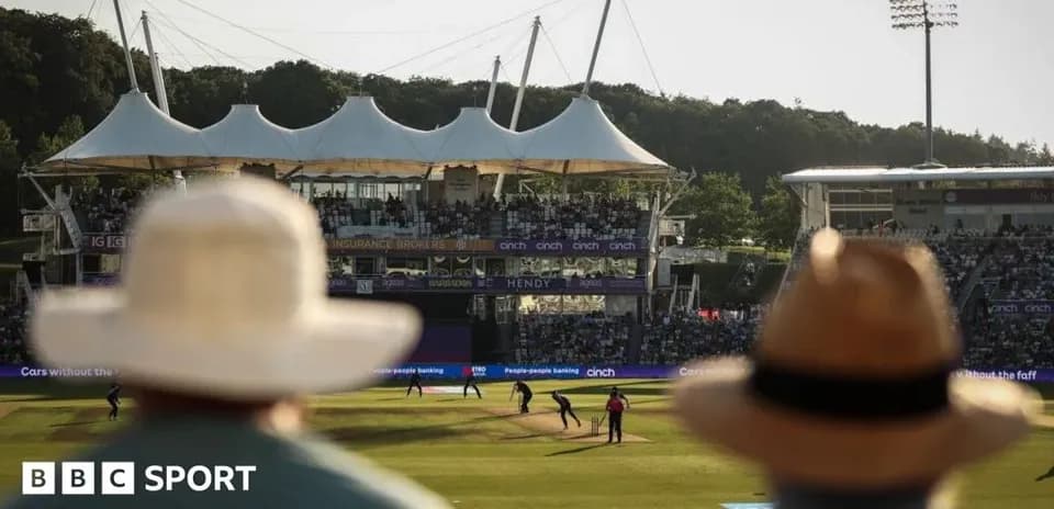 Cricket match with spectators in foreground