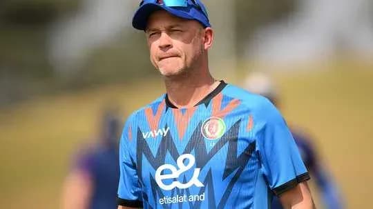 Cricket coach observing players during practice session