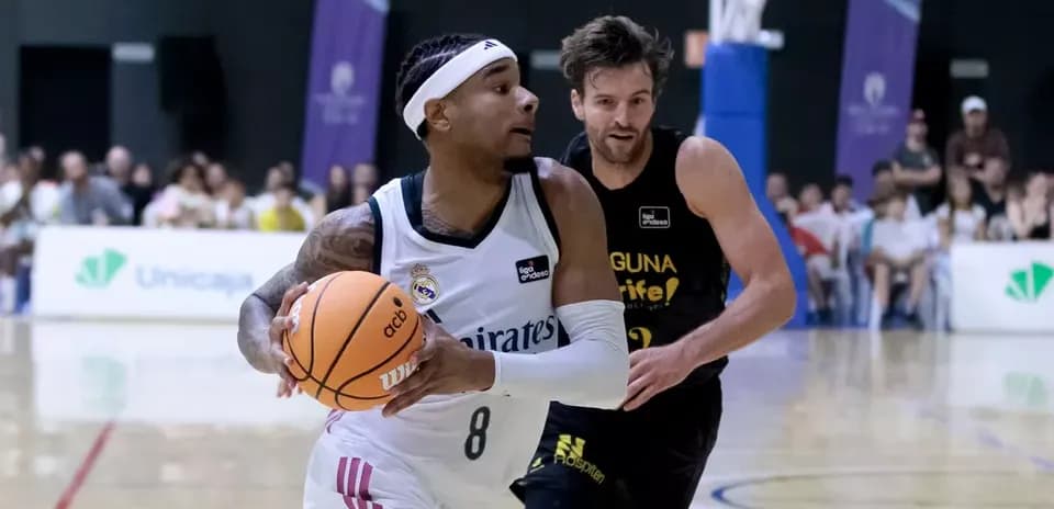 Player dribbling basketball with opponent in pursuit