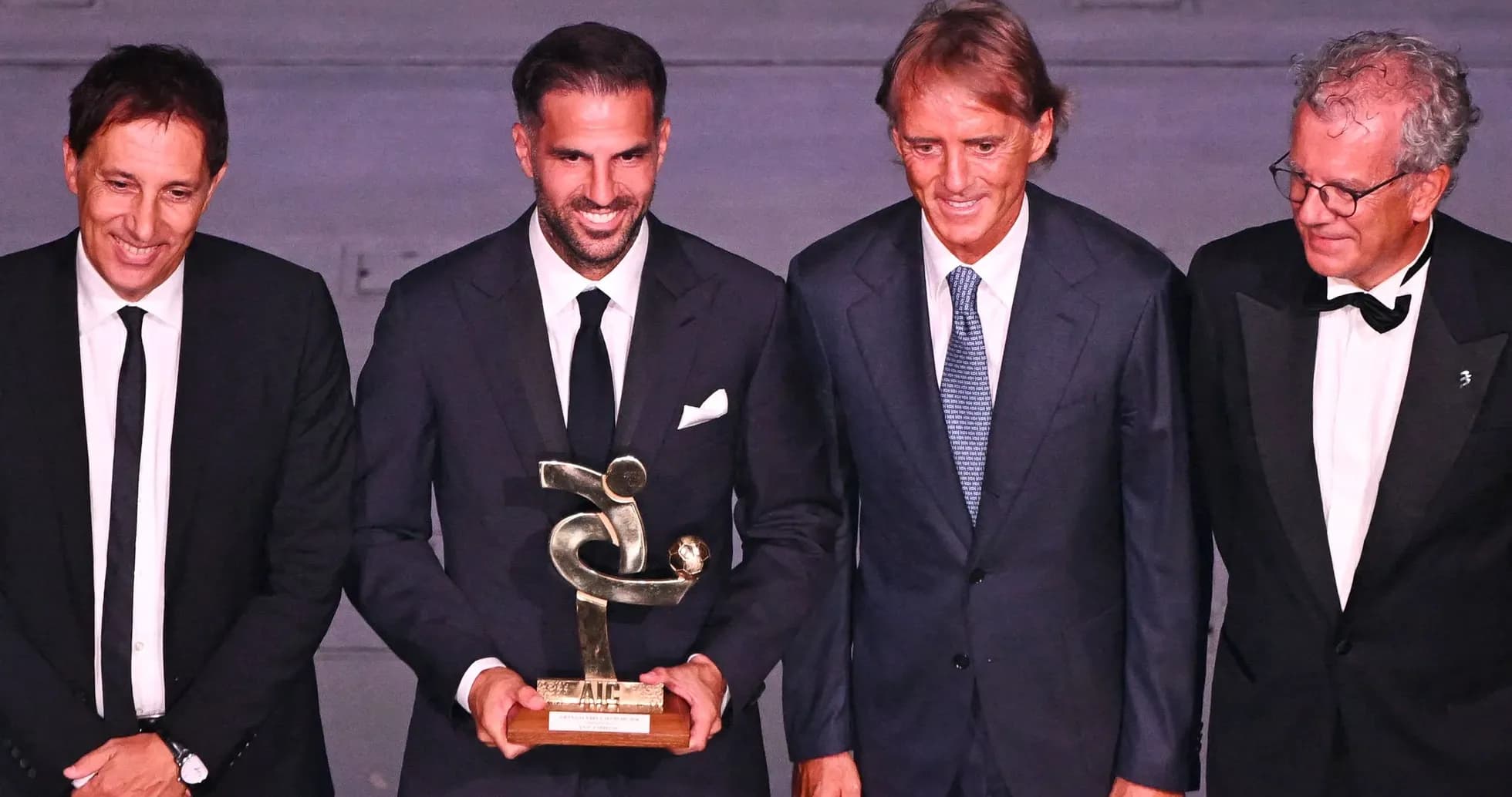 Four men at award ceremony holding trophy
