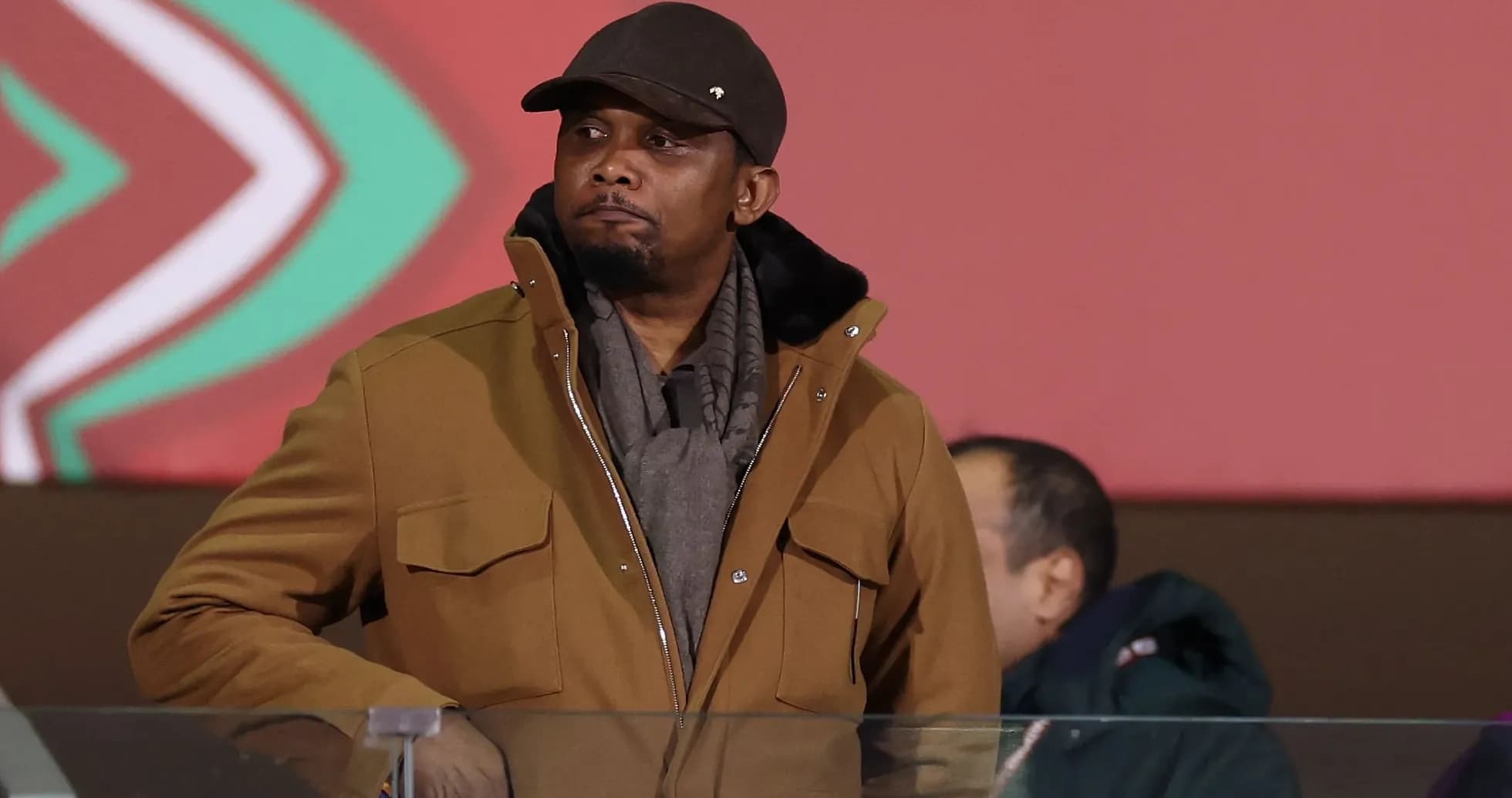 Man in brown coat watching an event