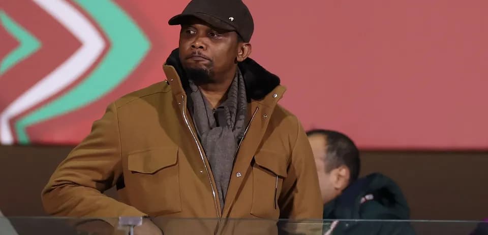 Man in brown coat watching an event