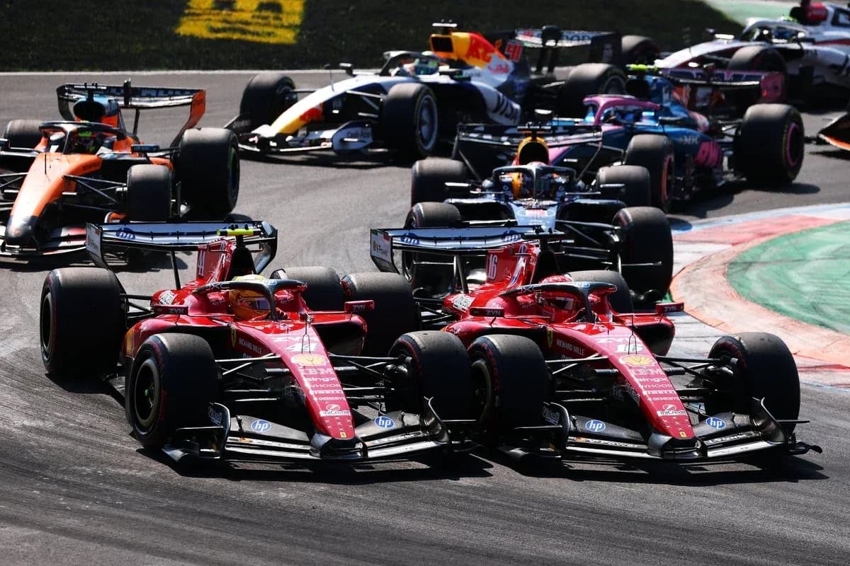 Two Ferrari cars racing closely in Formula 1 event Two Ferrari cars racing closely in Formula 1 event