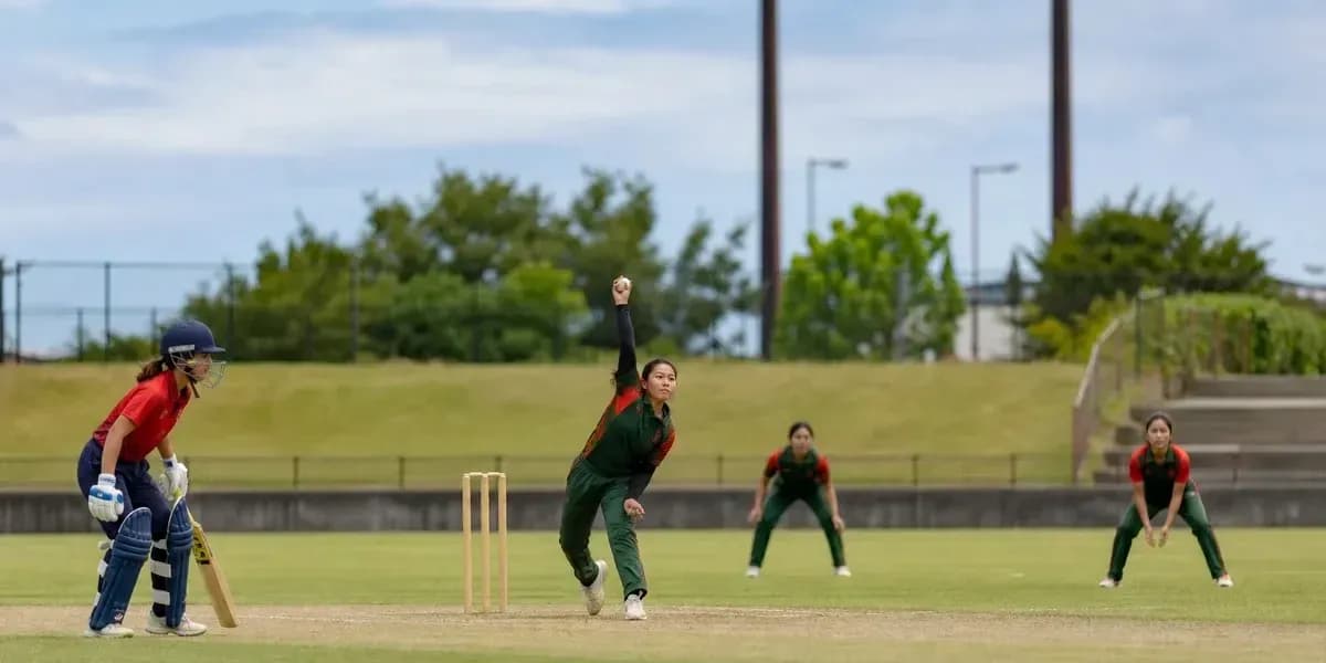Bowler delivering ball while batter prepares to hit Bowler delivering ball while batter prepares to hit