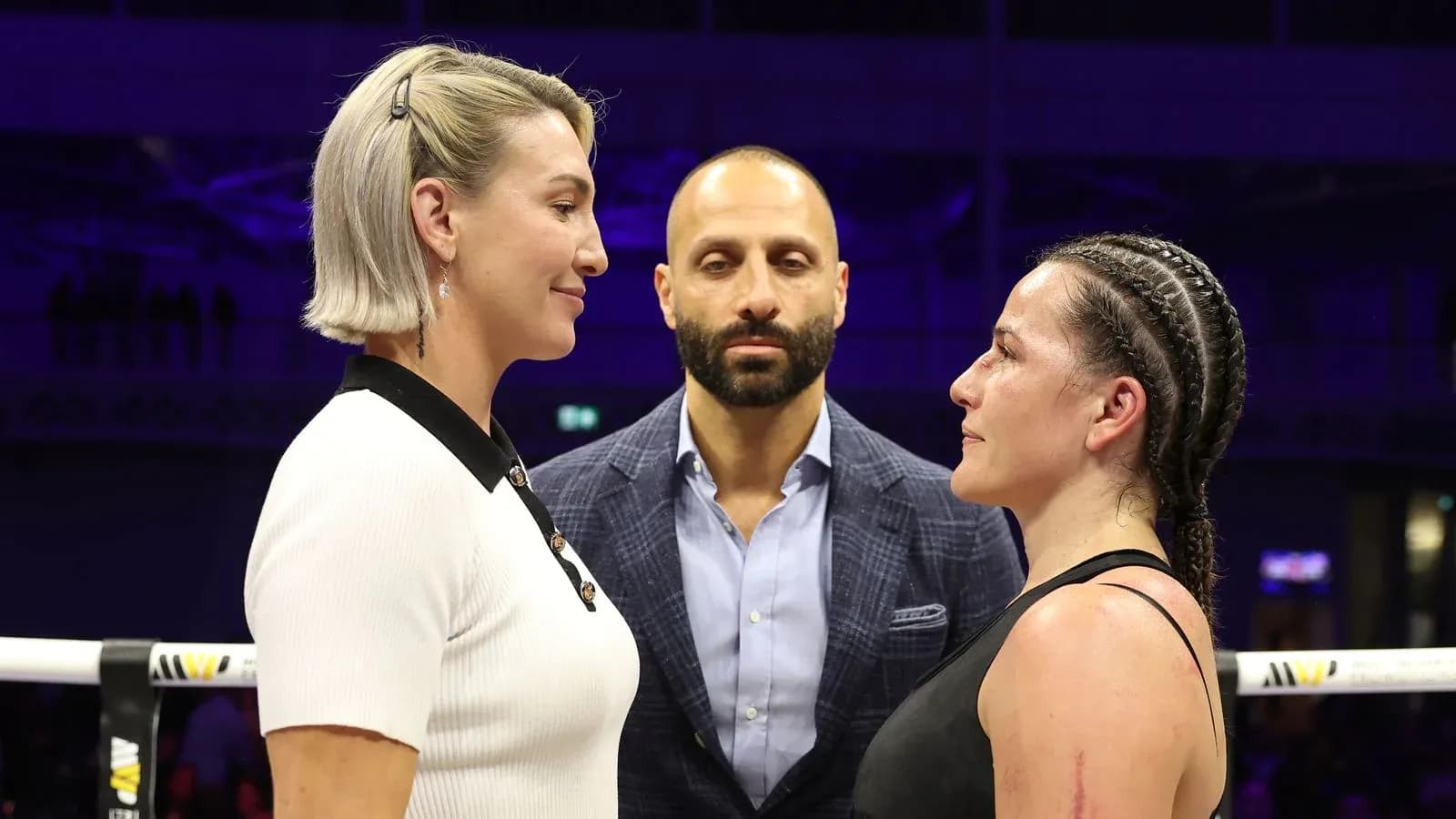 Two fighters facing off with a referee in between Two fighters facing off with a referee in between