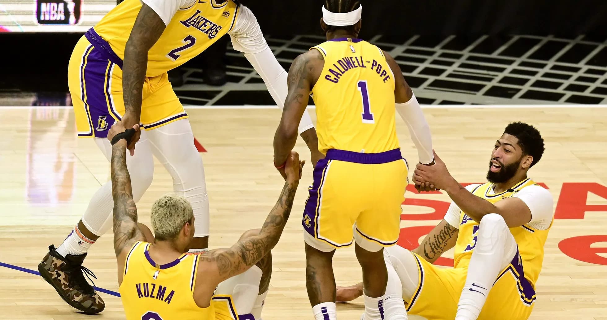 Lakers players helping each other after a play Lakers players helping each other after a play