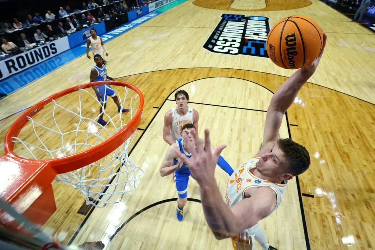 Player dunking during NCAA basketball tournament game Player dunking during NCAA basketball tournament game