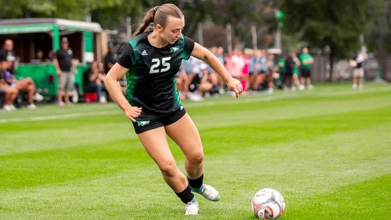 Player number 25 kicking soccer ball on field Player number 25 kicking soccer ball on field
