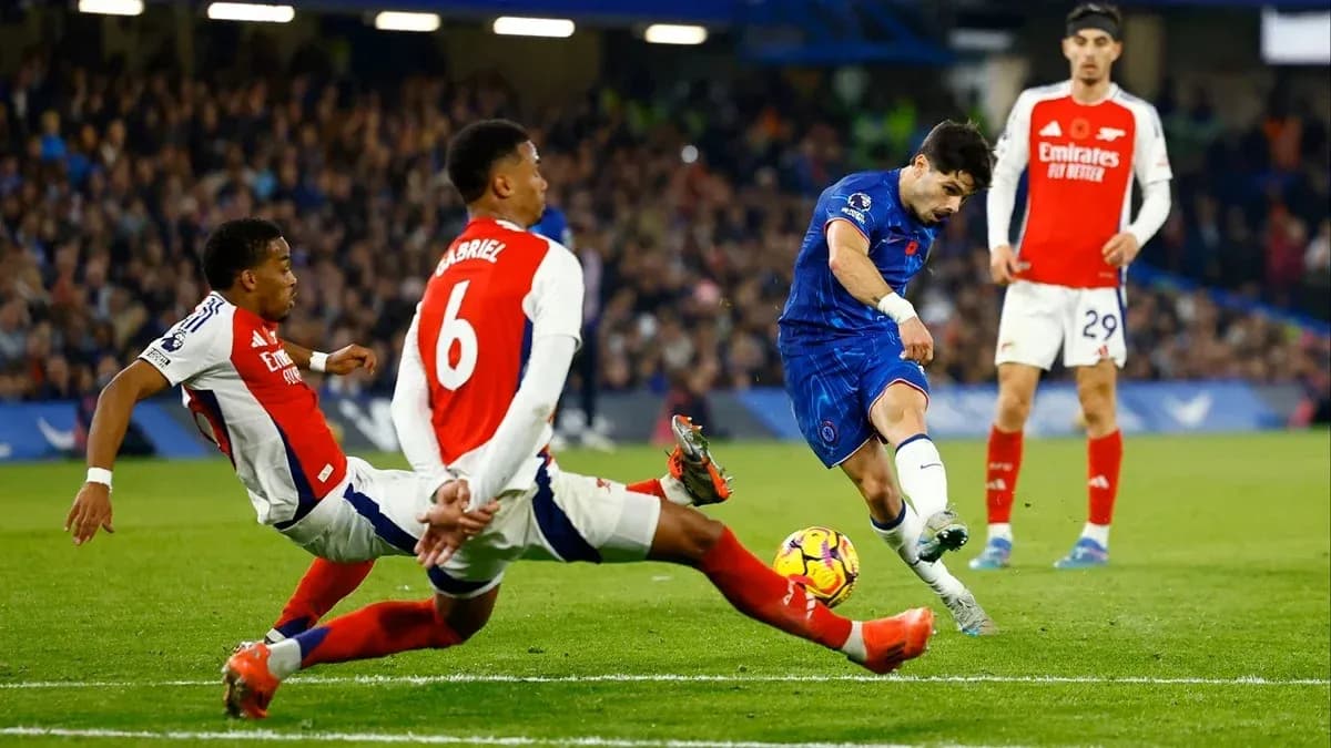 Chelsea player shooting while Arsenal defenders attempt tackle Chelsea player shooting while Arsenal defenders attempt tackle