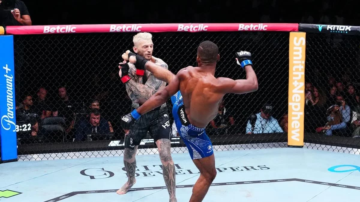 Two fighters engaged in a striking exchange in octagon Two fighters engaged in a striking exchange in octagon