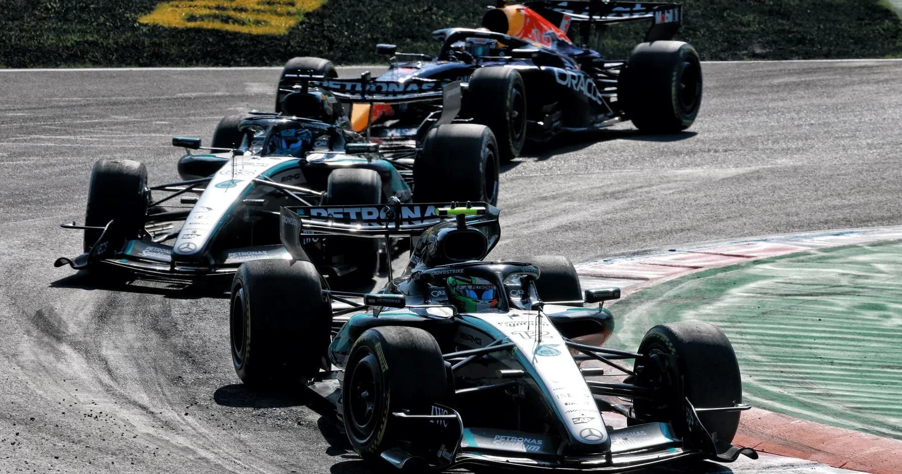 Three Formula 1 cars racing on track during competition Three Formula 1 cars racing on track during competition