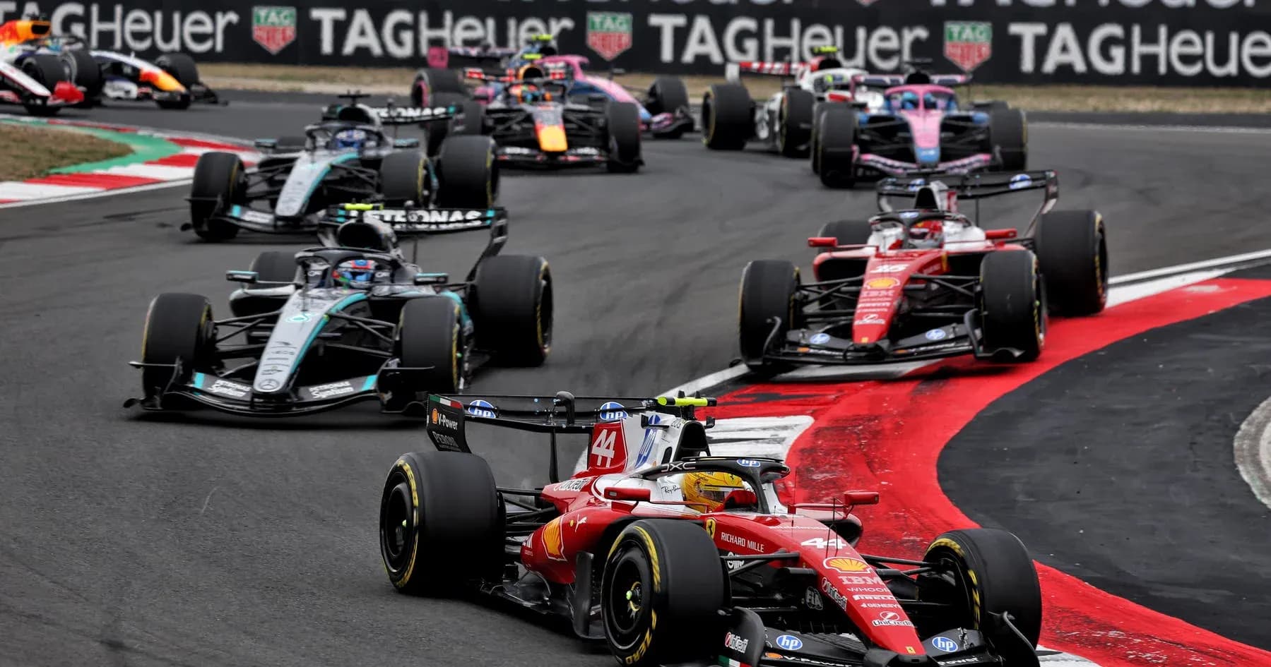 Multiple Formula 1 cars racing on track Multiple Formula 1 cars racing on track