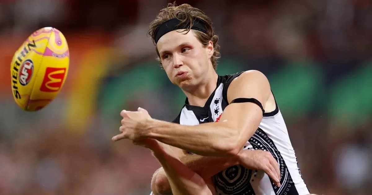 Player passing the ball during AFL match Player passing the ball during AFL match