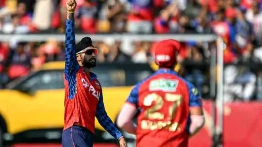 Bowler celebrating wicket with teammate on field Bowler celebrating wicket with teammate on field