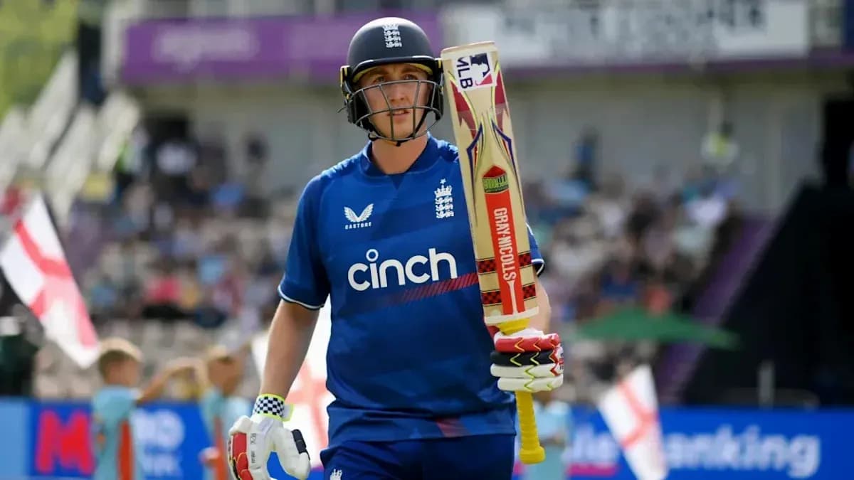 Cricketer walking onto the field with bat Cricketer walking onto the field with bat