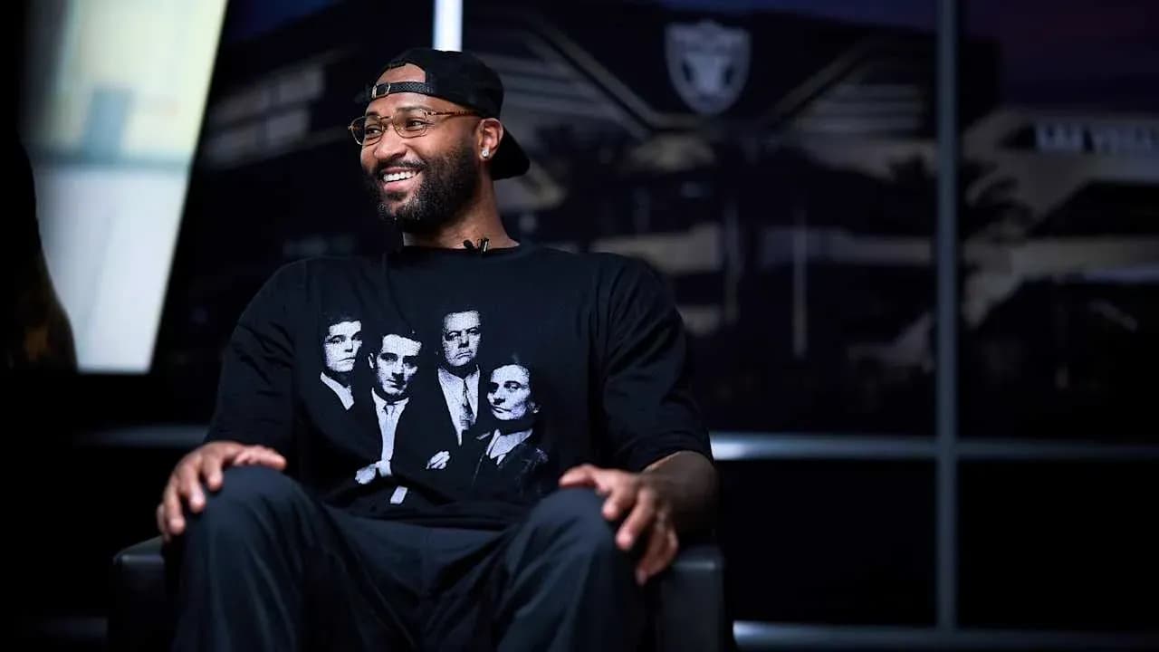 Player seated in interview setting wearing graphic t-shirt Player seated in interview setting wearing graphic t-shirt