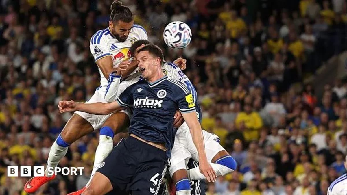 Players contesting a header during a football match Players contesting a header during a football match