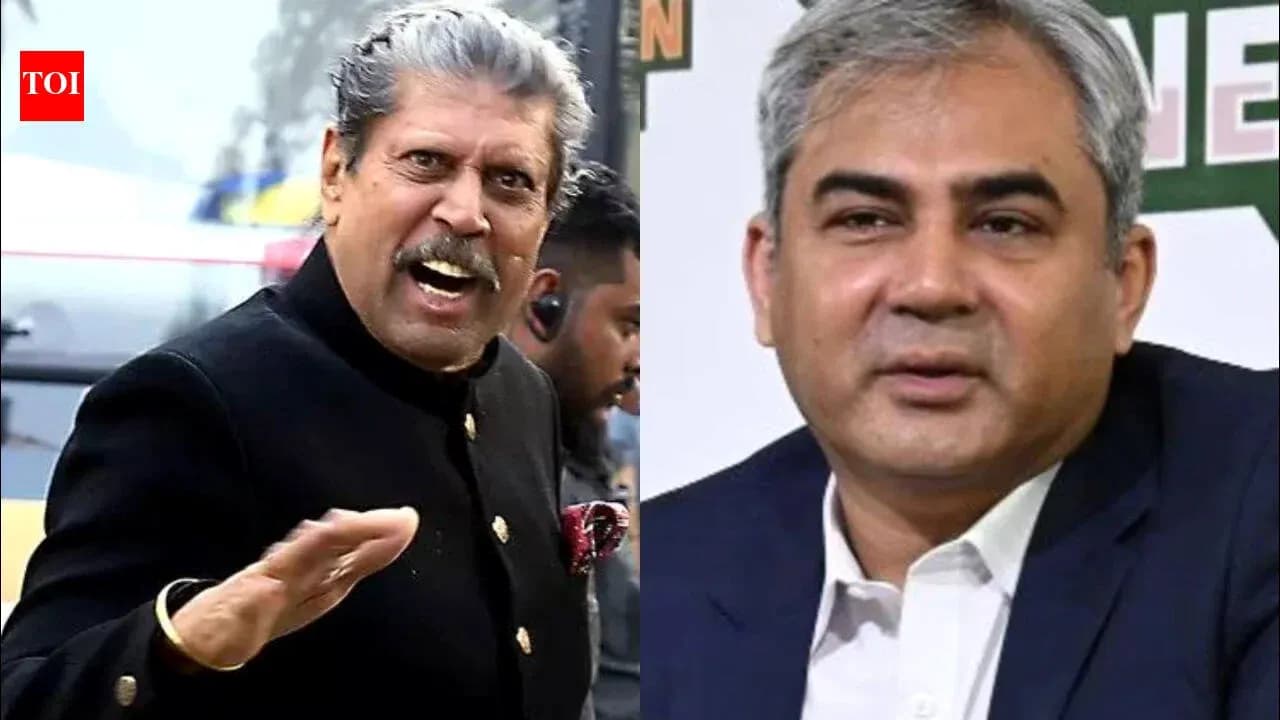 Two men speaking at an event with microphones Two men speaking at an event with microphones