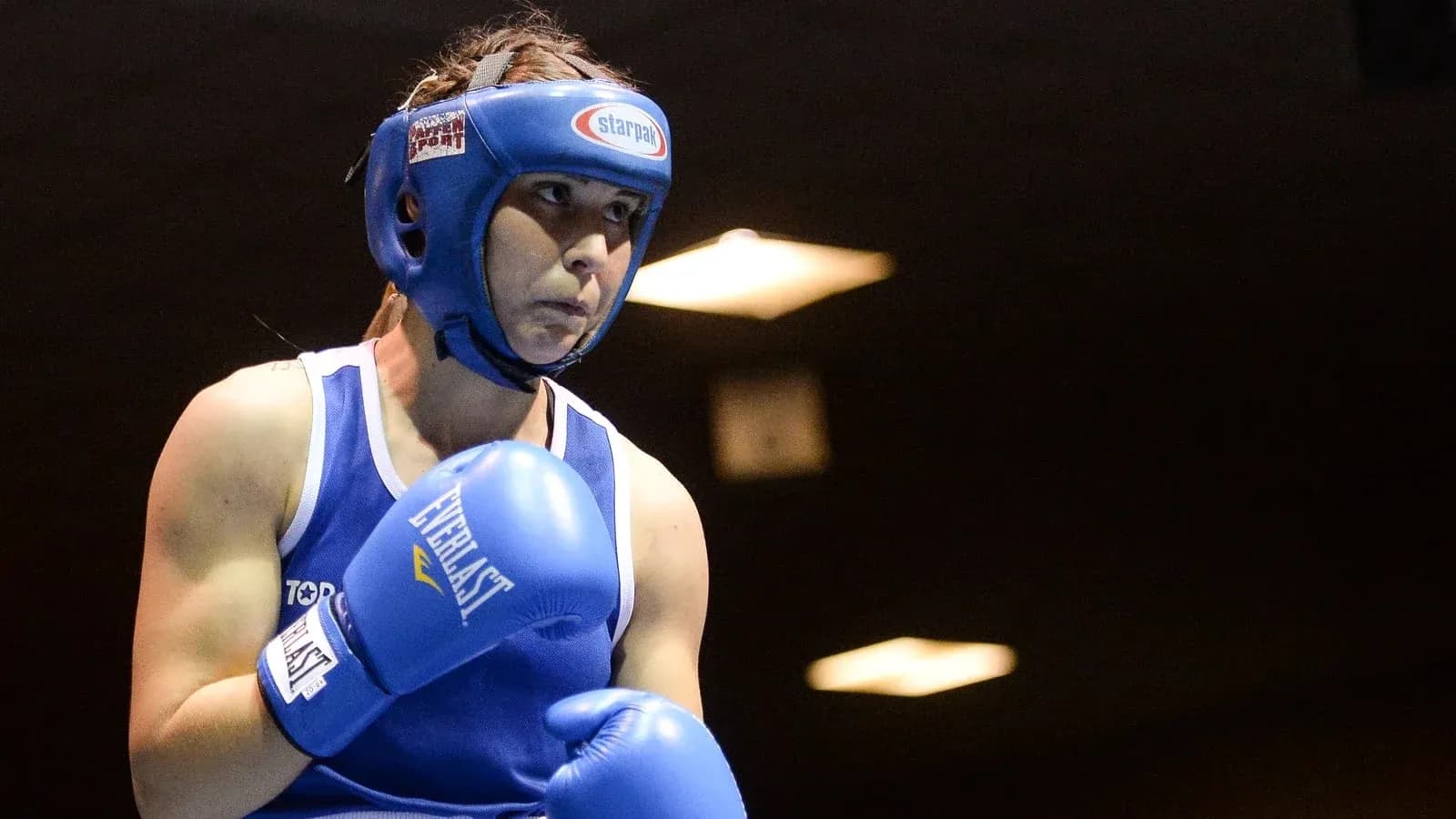Female boxer in blue gear preparing for match Female boxer in blue gear preparing for match
